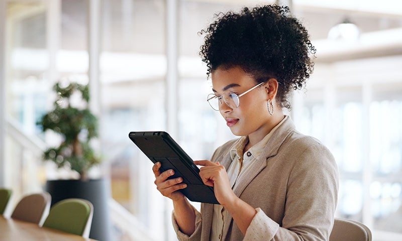 Professional woman at a conference room table using a tablet